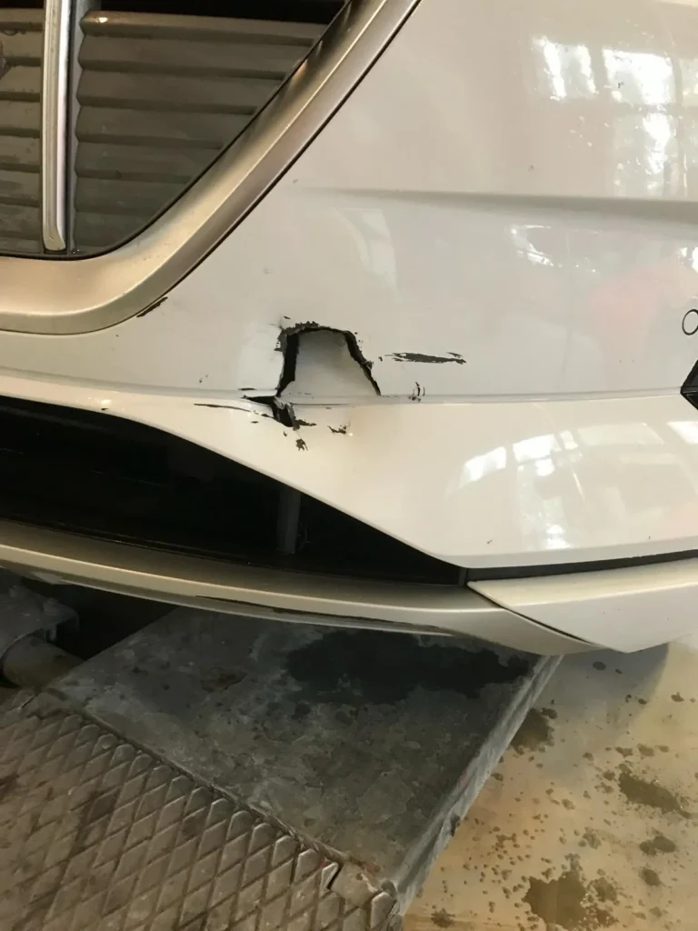 Witte auto met gescheurde voorbumper