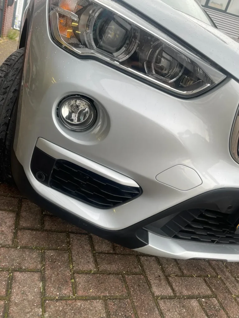 Zilveren auto na herstel van de voorbumper